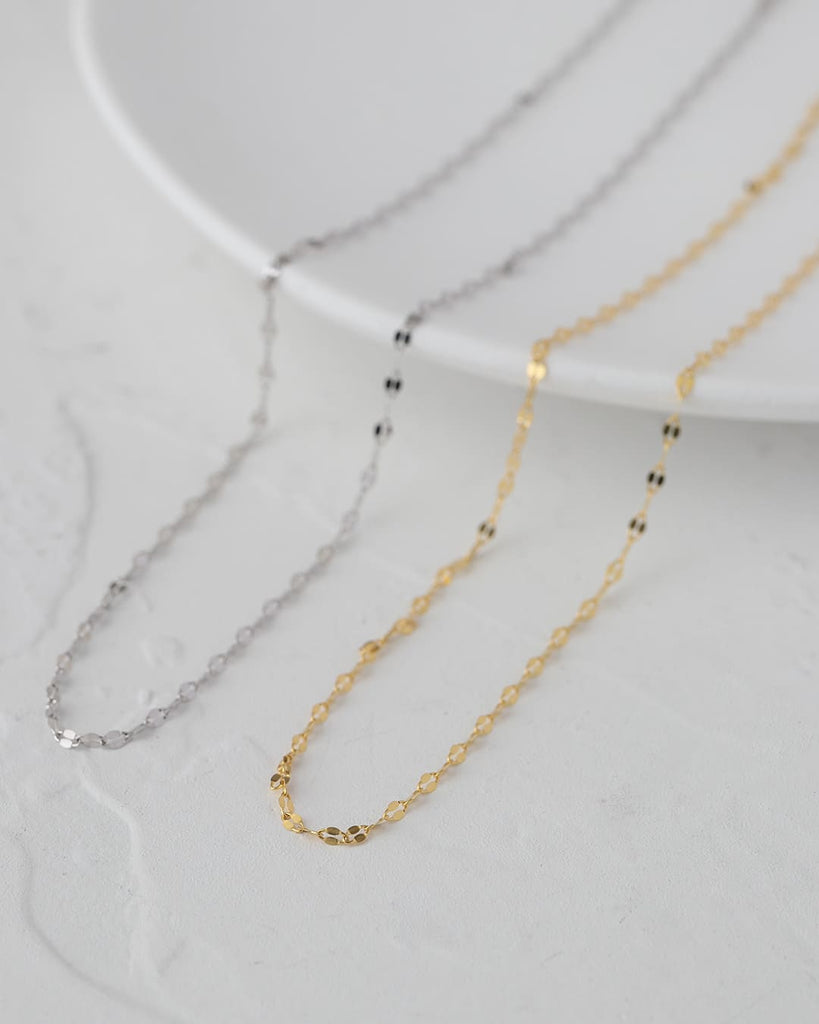 繊細な輝きが首元にそっと寄り添う、ペタルチェーンネックレス